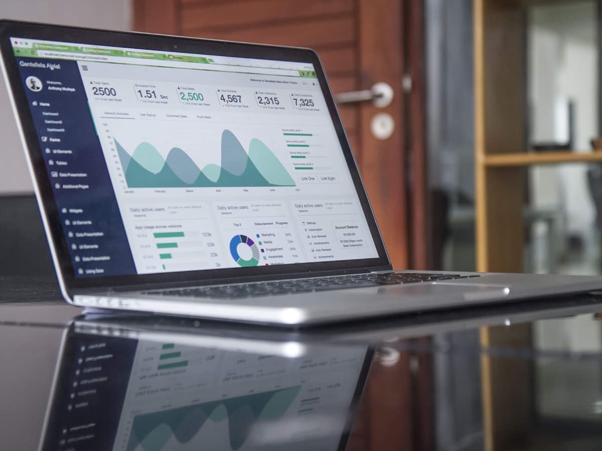 An analytics dashboard open on a laptop on a glass desk