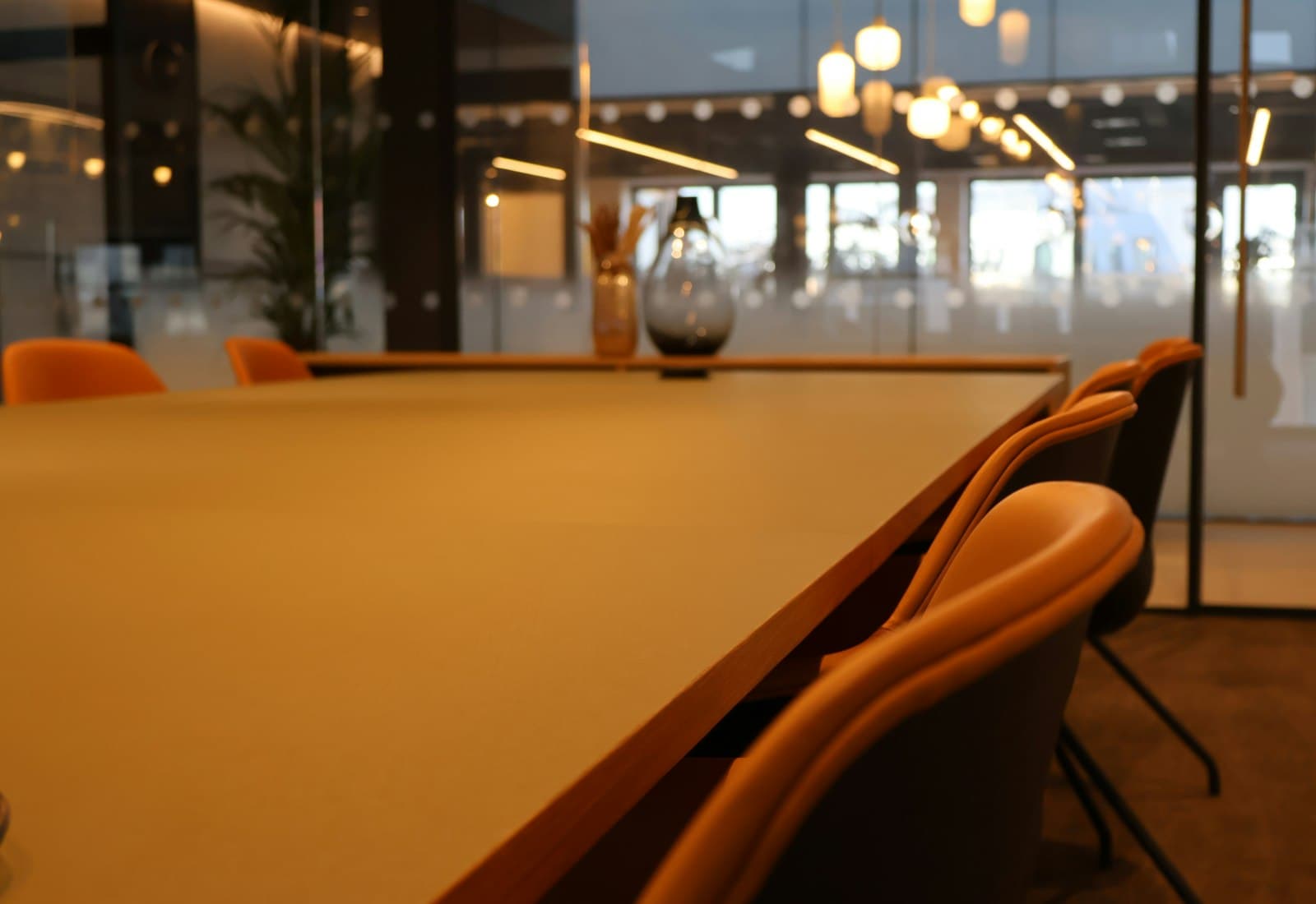 A meeting room with a long table and city view